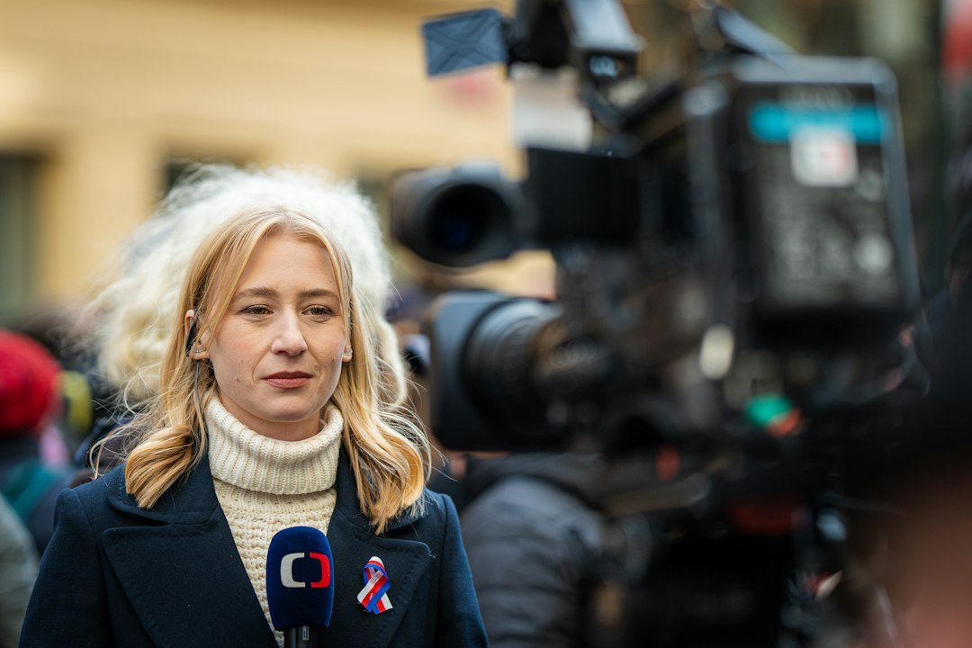 Reporter standing in front of a television camera during a news broadcast